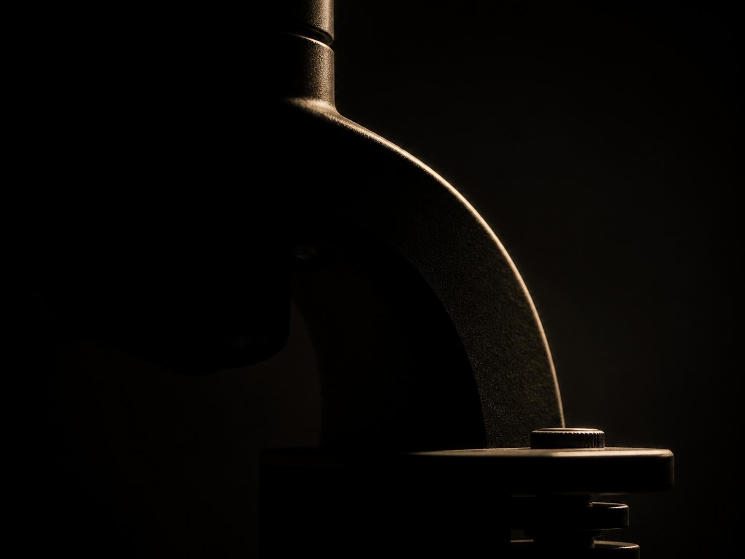 The partial silhouette of a diagnostic instrument dissolving into shadow.